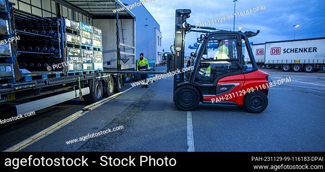 PRODUCTION - 21 November 2023, Mecklenburg-Western Pomerania, Rostock: Pallets and transported goods are unloaded from trailers belonging to the logistics...