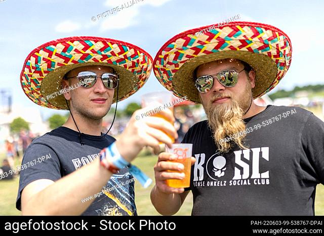 03 June 2022, Bavaria, Nuremberg: Wearing sombrero and sunglasses, Benji (l) and Dominik wait for the concert to start at the open-air ""Rock im Park"" festival