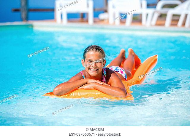 Adorable girl relaxing at the swimming pool