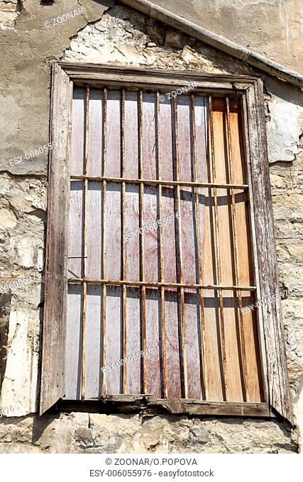Old locked window with lattice in vintage wall