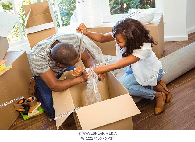 Ethnic couple unwrapping their stuff in boxes