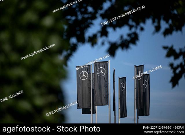 12 July 2022, Baden-Wuerttemberg, Stuttgart: The Mercedes star can be seen on flags in front of the Mercedes-Benz headquarters in Untertürkheim