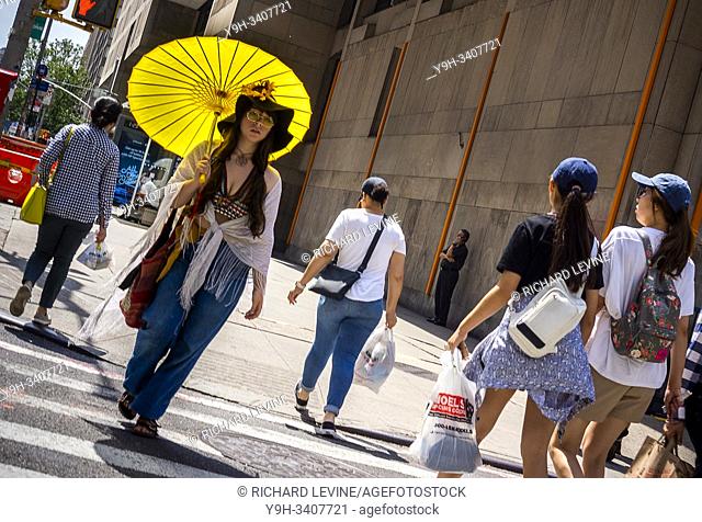 A woman channels the 1960Õs as she walks on Seventh Avenue in New York on Tuesday, August 20, 2019