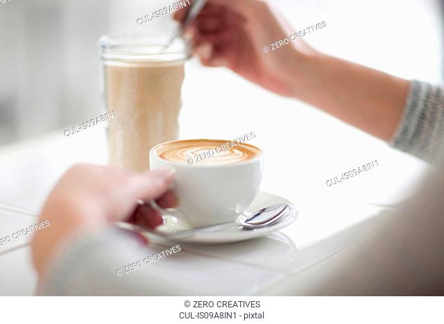 Woman in cafe with coffee cup, close up