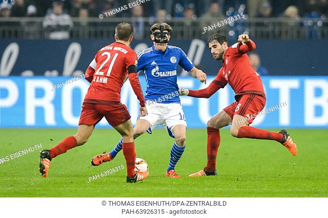 Munich's Philipp Lahm (L) and Javier Martinez (R) and Schalke's Fabian Reese vie for the ball at the German Bundesliga soccer match between FC Schalke 04 and FC...