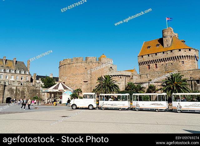 Saint-Malo, Ille-et-Vilaine / France - 19 August 2019: tourist sightseeing train waits for passengers outside the city walls of the old town of Saint-Malo in...