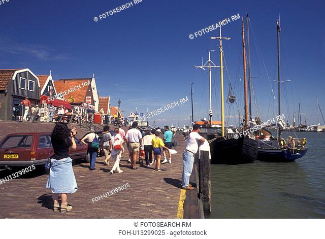 Netherlands, Holland, Volendam, Noord-Holland, Europe, People walking along the waterfront on the harbor on Markermeer in the town of Volendam