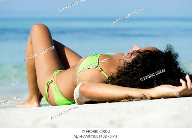 Woman in bikini sunbathing on beach
