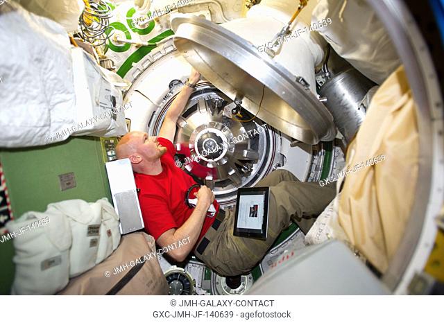 European Space Agency astronaut Alexander Gerst, Expedition 40 flight engineer, prepares to remove the docking mechanism to gain access to the hatch of the...