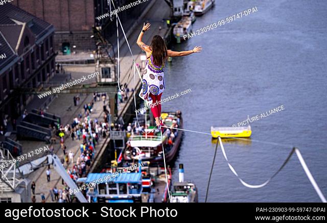 03 September 2023, Berlin: Rope acrobat Kasia balances on a high wire stretched between two towers at the celebration of the 100th anniversary of Berlin's...