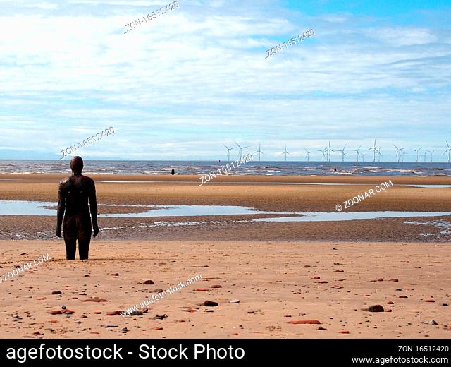 Southport, Merseyside, United Kingdom - 9 september 2020: statue of anthony gormley another place installation on the beach at seffton in southport with the...