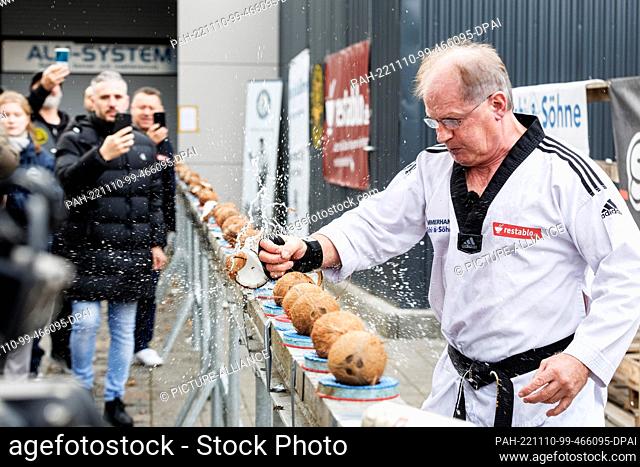 10 November 2022, Hamburg: Muhamed Kahrimanovic smashes 50 coconuts in 30 seconds with a raw egg in his beating hand at an event organized by the Record...