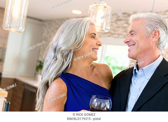 Caucasian couple drinking wine in kitchen