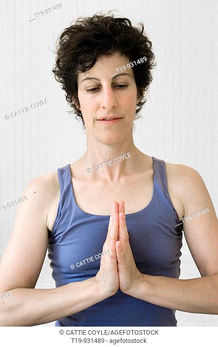 Woman doing yoga in a studio  Pose: 'Anjali mudra' a k a  'Namaste'  MR