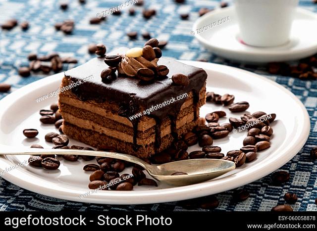 chocolate cake and coffee beans on white plate