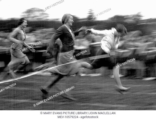 Racing women reach the finishing line in this high-speed action shot