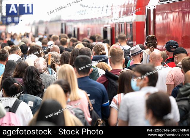 03 June 2022, Hessen, Frankfurt/Main: Passengers walk tightly packed to a regional train at the main station ahead of the Whitsun weekend