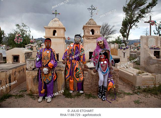 Revellers in costumes and masks at a cemetery in Humahuaca during carnival in Jujuy province in the Andes region of Argentina
