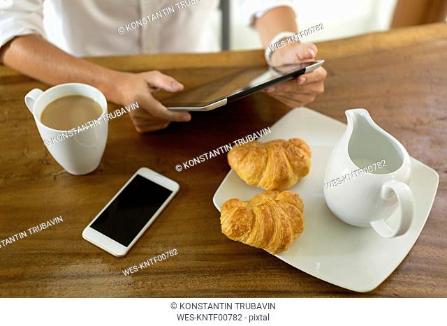 Woman at breakfast table using tablet