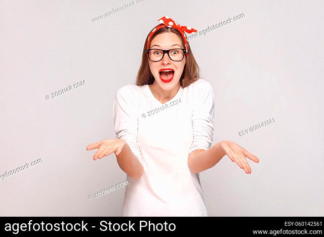 how you did this? it's unbelievable. portrait of beautiful emotional young woman in white t-shirt with freckles, black glasses, red lips and head band