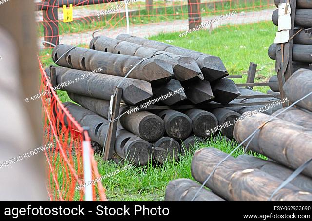 Pile of wooden poles for construction, selective focus
