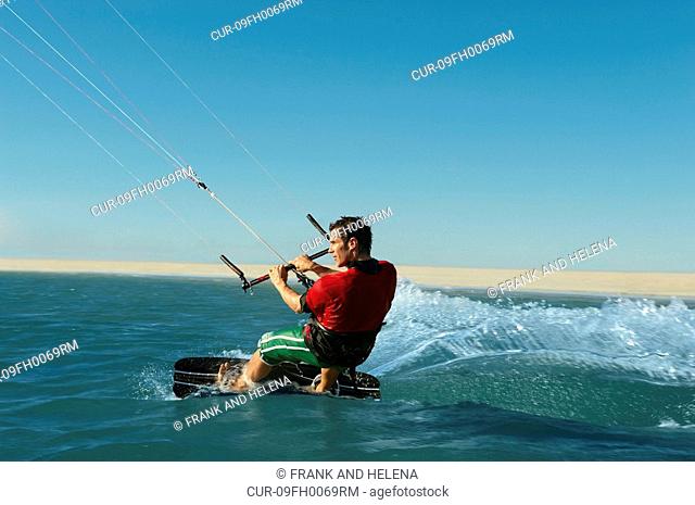 Man kitesurfing near beach