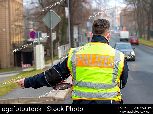 11 December 2020, Saxony, Görlitz: A policeman of the federal police signals a driver coming from Poland that he has to stop for a check