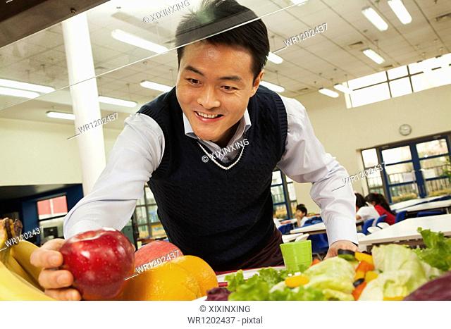 Teacher reaching for healthy food in school cafeteria