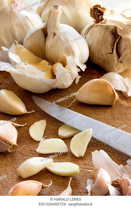 organic garlic and freshly cut tubers arranged as natural still life of healthy and vegetarian food on a wooden background