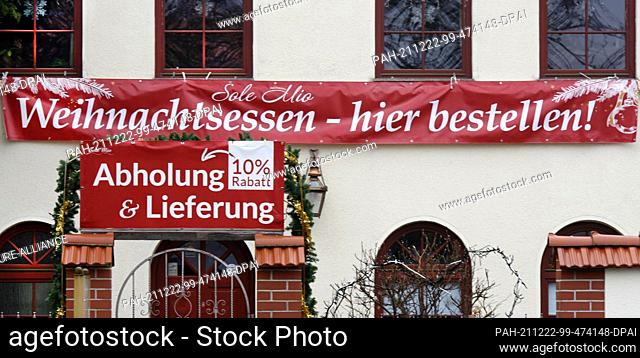 21 December 2021, Saxony, Leipzig: In the city's southeast, a restaurateur is advertising Christmas dinner orders for pickup at 10 percent off and delivery