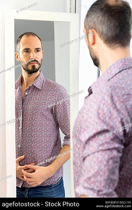 A man looking in a mirror to give him self-confidence