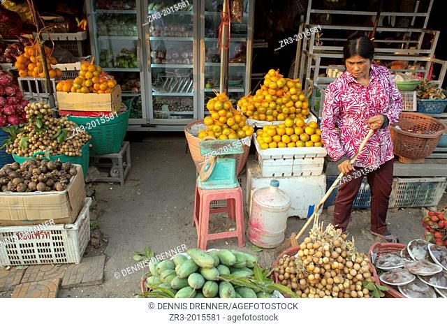 A Cambodian woman cleans up her fruit and vegetable stall at a marketplace in Phnom Penh, Cambodia