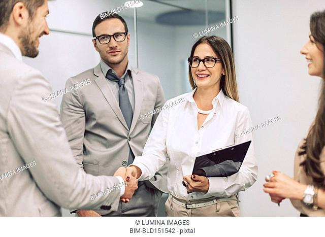 Caucasian business people shaking hands in office