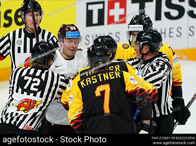 01 June 2021, Latvia, Riga: Ice hockey: World Championship, preliminary round, Group B, Germany - Latvia: Germany's Fabio Wagner (hidden) and Maximilian Kastner...