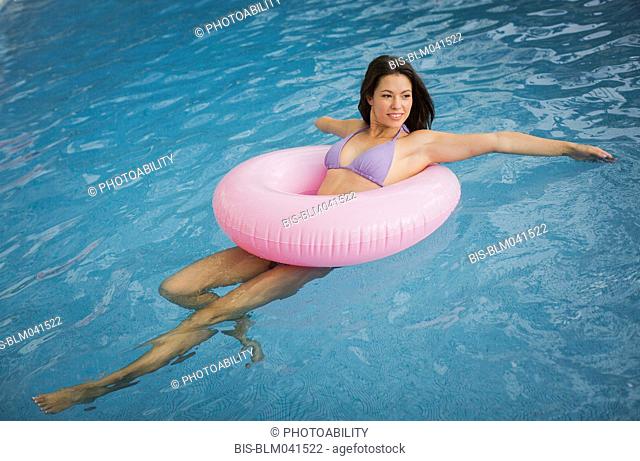 Mixed race amputee woman swimming in pool
