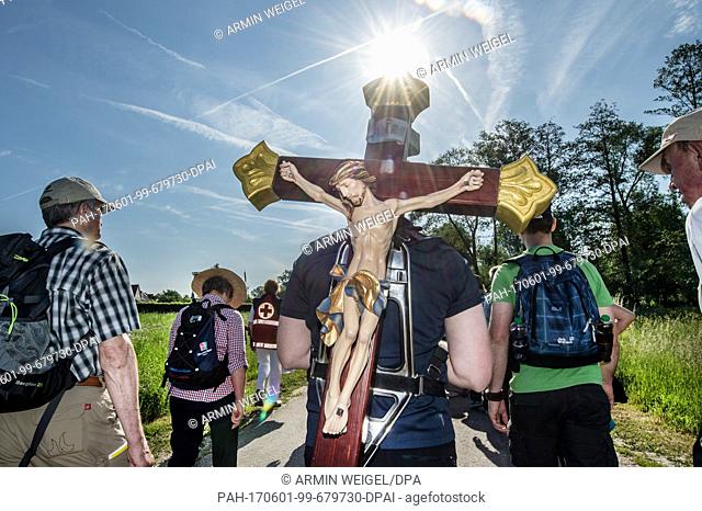 A pilgrim carries a wooden cross on Germany's largest pilgrimage in Regensburg, Germany, 1 June 2017. By Saturday, the pilgrims plan to walk from Regensburg to...