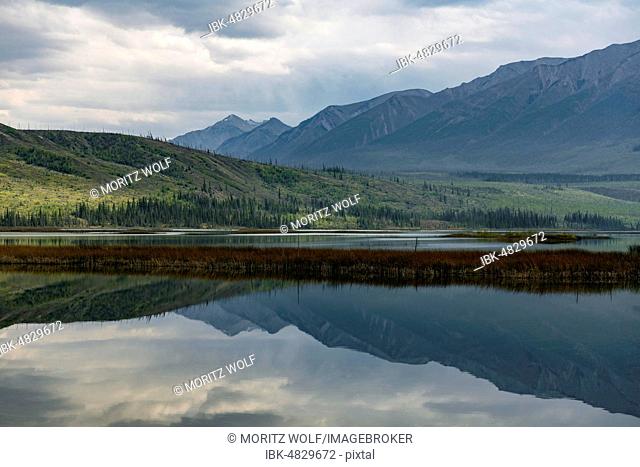Hilly landscape reflected in a lake, Talbot Lake, Jasper National Park, British Columbia, Canada