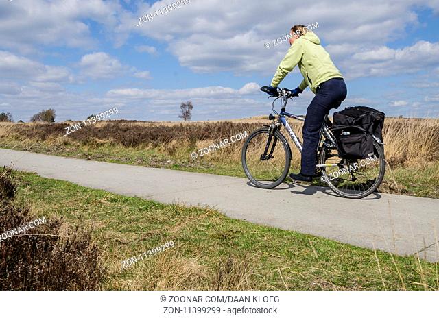 Woman on a bike in the nature reserve Elspeetsche Heide