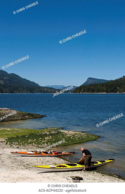 Kayaker on Russell Island with view to Fulford Harbour, Saltspring Island, British Columbia, Canada