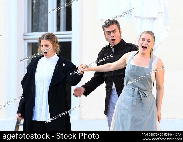 28 July 2021, Brandenburg, Rheinsberg: The singers Larissa Angelini (l) as Leonore (Fidelio) and Daniela Ruth Stoll (r) as Marzelline and singer Bartosz Szulc...