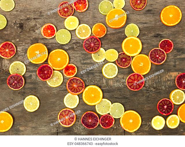 a lot of different juicy and healthy citrus fruits lie together on an old, vintage wood background