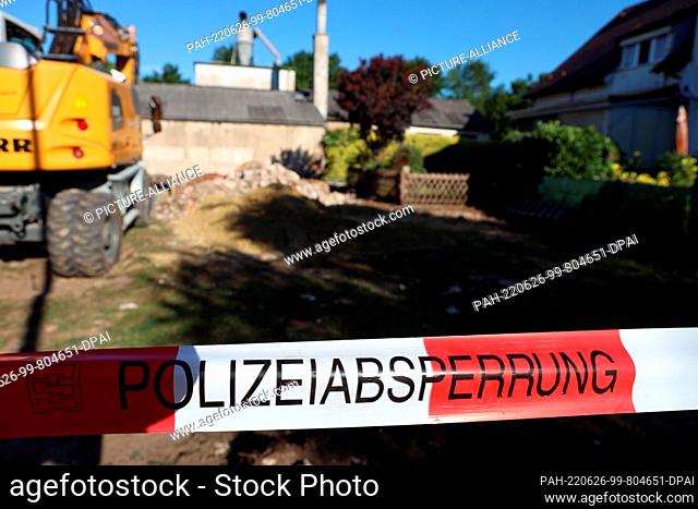 26 June 2022, Bavaria, Regensburg: An excavator stands behind a police cordon on a plot of land where a bomb from World War II was found