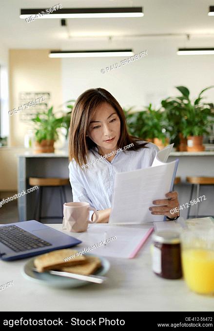 Businesswoman reviewing paperwork in office lounge