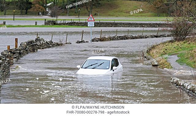 Abandoned car stuck in floodwater on road, near Hawes, Wensleydale, Yorkshire Dales N.P., North Yorkshire, England, November