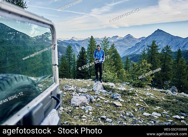 Tourist standing on rock in front of mountain range