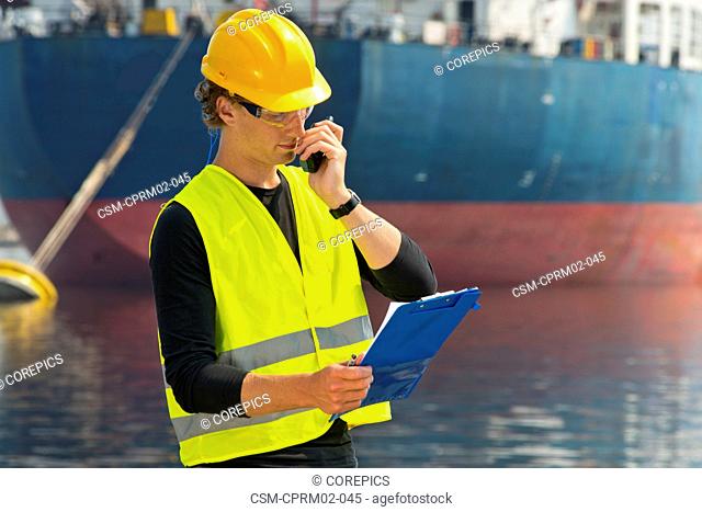 Engineer, reading out instructions from the notes on his clipboard over the radio