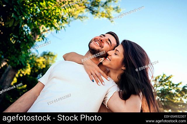 Young, happy couple walking in the summer park