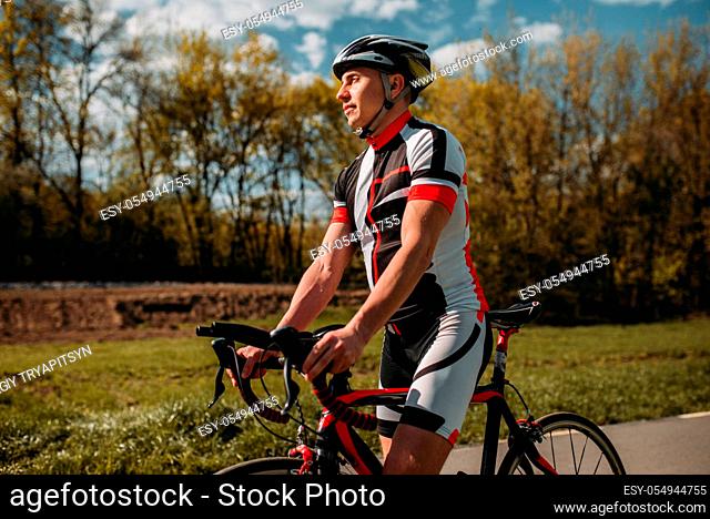 Bicyclist in helmet and sportswear on sport bicycle. Training on bike path, cycling workout
