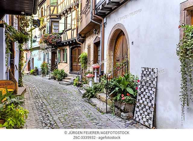 houses in the small old village Eguisheim, Alsace, France, lane with timbered houses and flower decoration