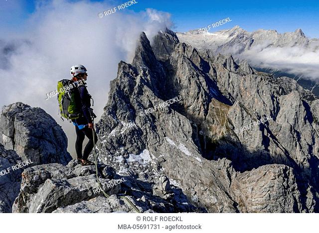 Mountaineer at the Schüsselkarspitze west ridge, view at Wetterstein Range with Scharnitzspitze and Oberreintalschrofen and Hochwanner and Zugspitze and...